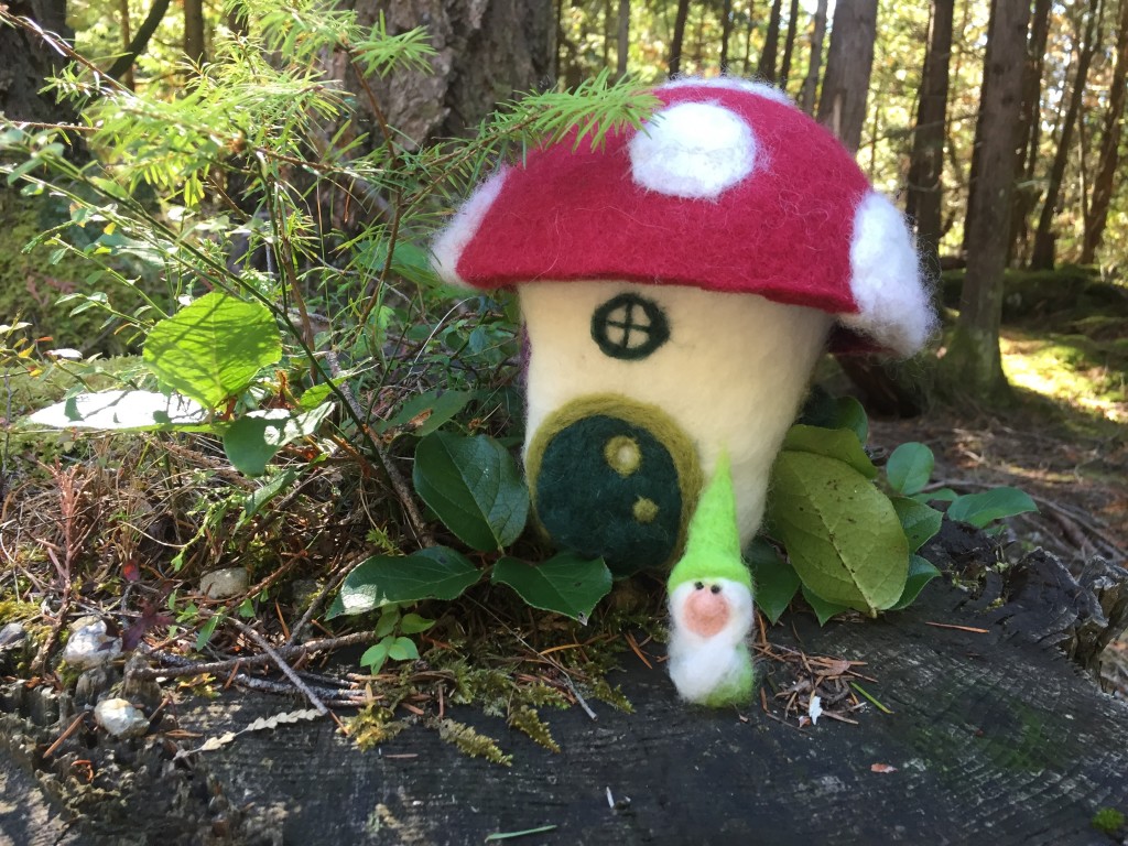 a white bearded gnome in the forest outside is fuzzy woolen mushroom house